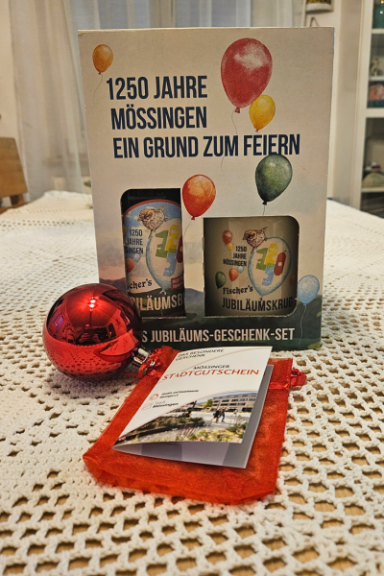 Geschenkset zum Jubiläum von Mössingen mit Glaskugel und einer Broschüre.