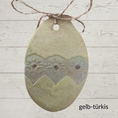 Kunstvoll gestaltete ovale Anhänger in Gelb-Türkis mit Muster.