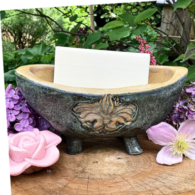 Schöne Schale mit floralem Relief, umgeben von Blumen.