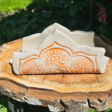 Kunstvoll gestalteter Serviettenhalter in Naturtönen und oragenem Ornament